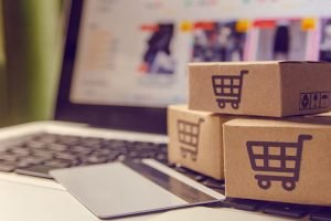 Shopping online concept - Shopping service on The online web. with payment by credit card and offers home delivery. parcel or Paper cartons with a shopping cart logo on a laptop keyboard